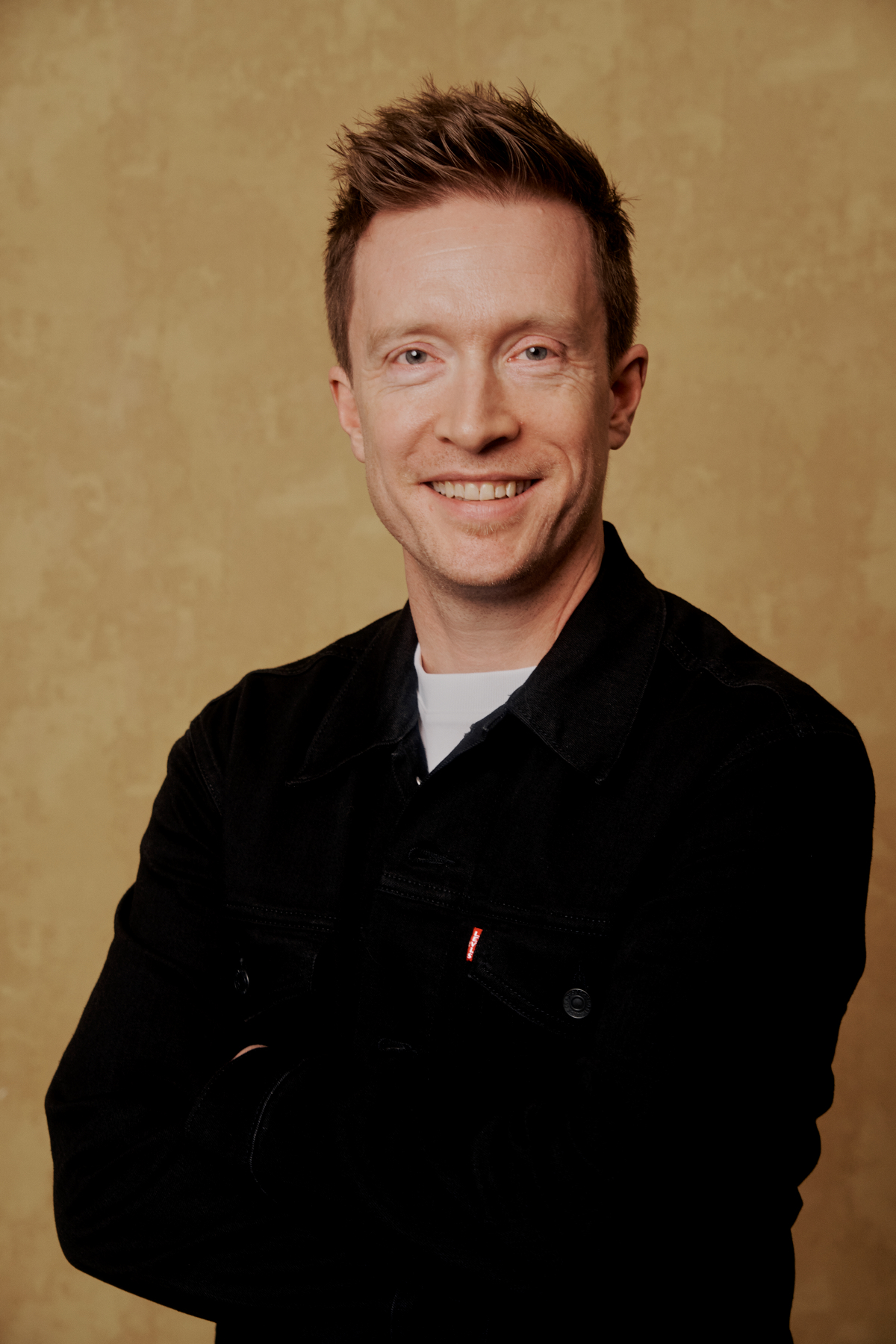 Olly Richards, smiling, in a black jacket.